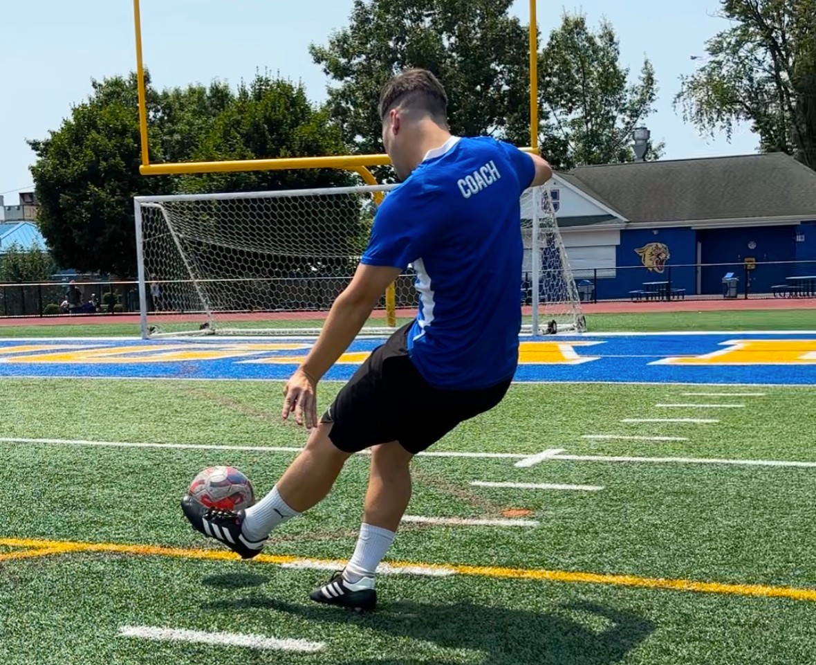 Coach Cufi striking a ball at a clinic